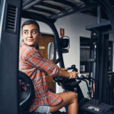 Shot of a young woman driving a forklift