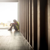 Stressed despair staff in logistic business sittng in container box at shipyard