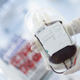 Nurse holding blood transfusion bag.